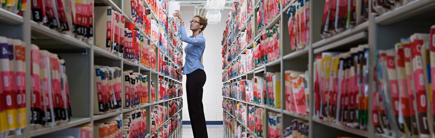 A medical assistant goes through files while working in a lab