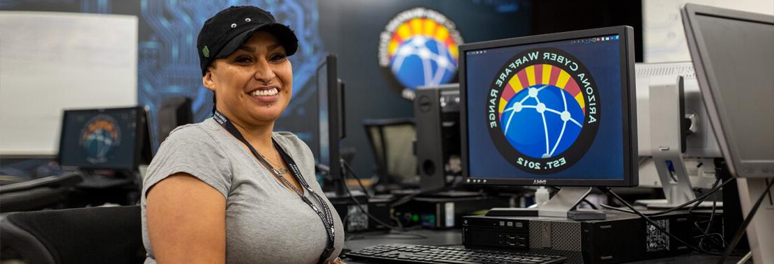 Aurora Sardina sits smiling in the Cyber Warfare Club room