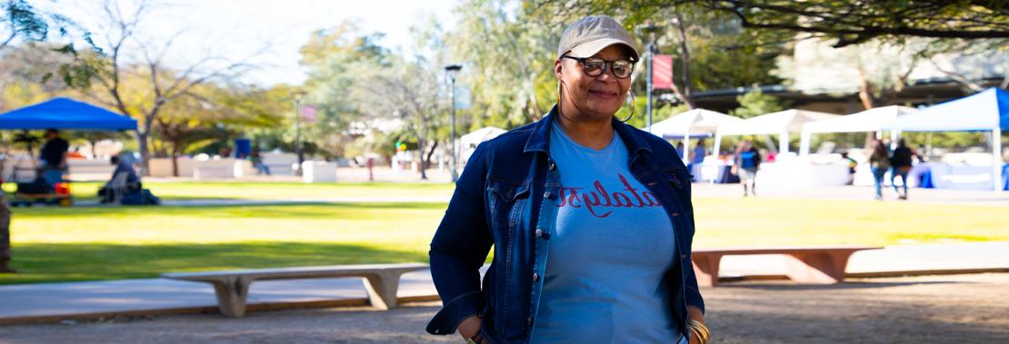 Treya Allen stands smiling in front of a Black 历史 Month Event at Downtown Campus