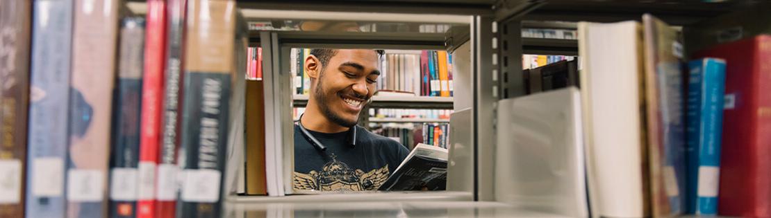 Student in the library stacks at Desert Vista campus library