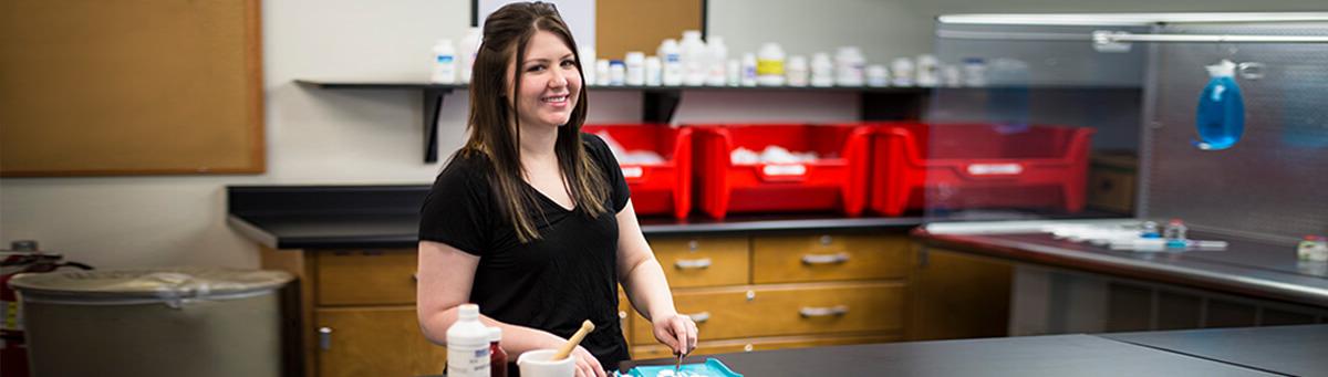 A student stands in front of a lab table in a Pima science lab