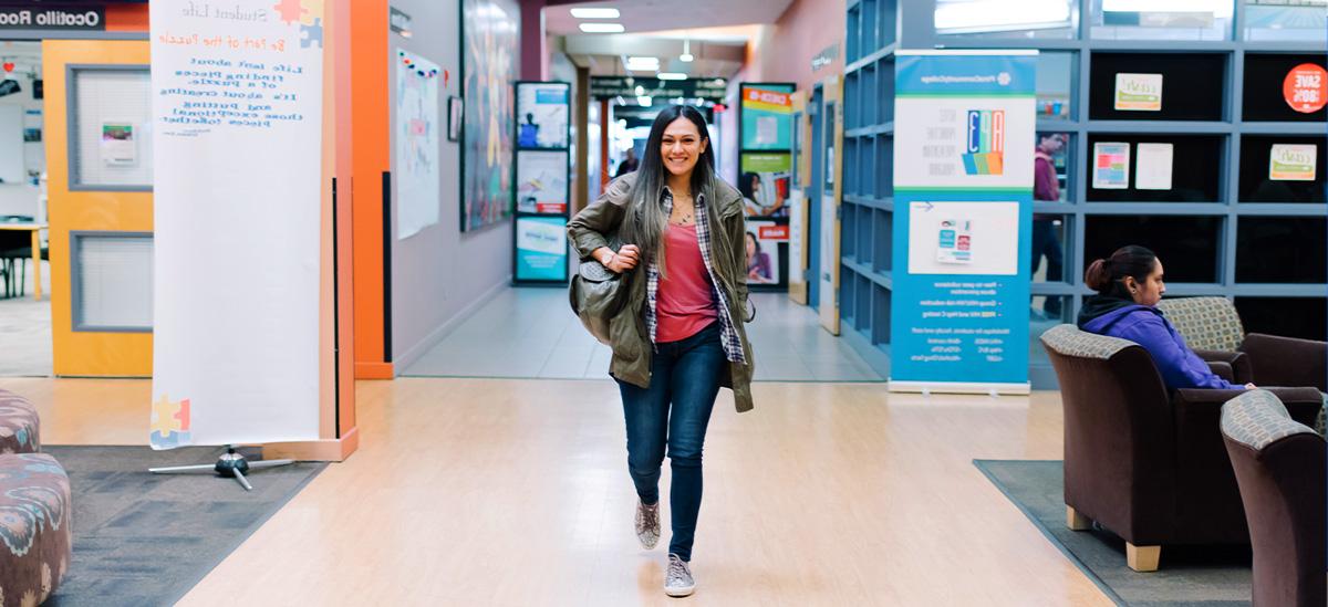 An student walks down a hall at a Pima campus